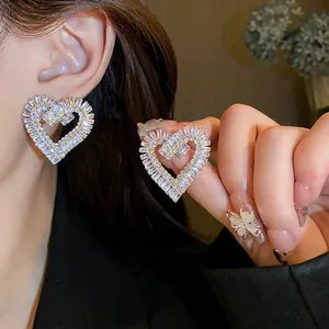 Primo piano di orecchini a cuore in zircone scintillante con perni in argento