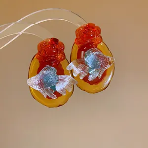 Detailed view of handmade resin earrings featuring translucent koi fish and red roses