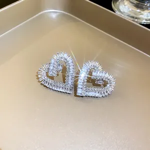 Primo piano dettagliato di orecchini a cuore scintillanti con zirconi baguette