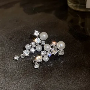 Macro di orecchini in argento con eleganti perle bianche e zirconi cubici scintillanti