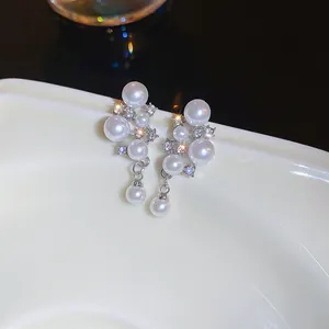 Primo piano di eleganti orecchini di perle a grappolo con strass luccicanti e finitura argento