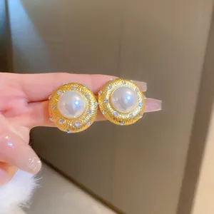 Close-up of vintage French court style pearl earrings with gold-toned rhinestone accents
