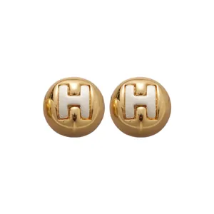 Minimalist round gold stud earrings with silver H-logo design for elegant fashion