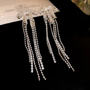 Detailed macro view of elegant silver zircon bowknot earrings with long hanging tassels