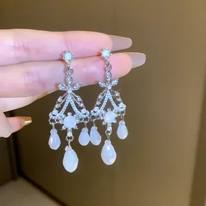 Dettaglio ravvicinato di orecchini vintage in argento con pietre bianche e strass