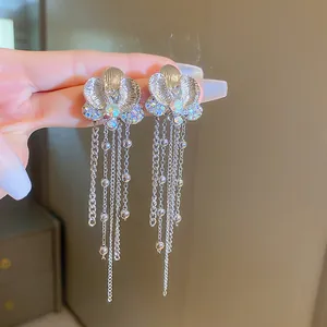 Eleganti orecchini a nappa con fiori d'argento e strass cangianti in dettaglio ravvicinato.