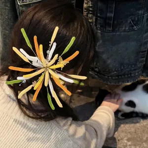 Detaillierte Nahaufnahme einer bunten beflockten Feuerwerk-Haarspange am Dutt.
