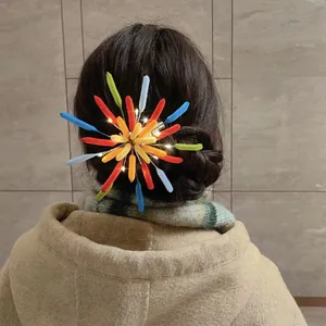 Detailansicht einer bunten, beflockten Feuerwerk-Haarklammer mit leuchtenden LED-Lichtern.