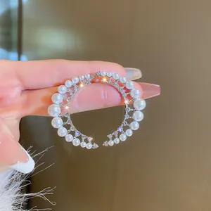Dettaglio ravvicinato di orecchini circolari eleganti decorati con perle e strass