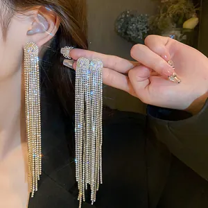 Close-up of sparkling long tassel earrings with oval zircon and silver needle
