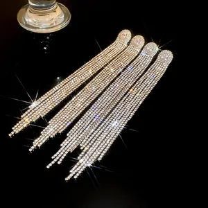 Detailed view of silver needle tassel earrings with oval zircon and sparkling rhinestones.