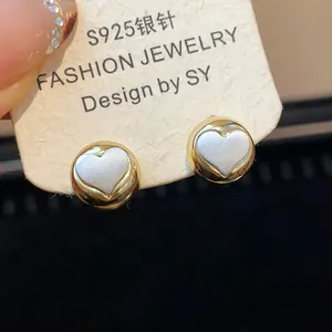 Close-up detail of minimalist heart stud earrings with S925 silver needle on card