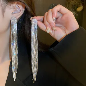 Detailed close-up of sparkling long tassel earrings with oval zircon stud