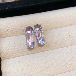 Detail view of elegant rectangular lavender zircon stud earrings in a soft cream jewelry tray