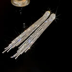 Close-up of silver long tassel earrings with oval zircon and sparkling rhinestones