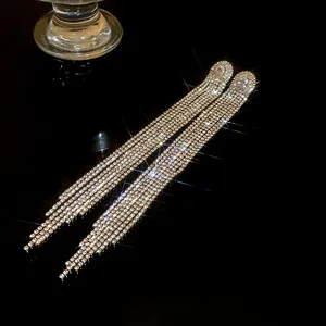 Macro shot of sparkling long tassel earrings with rhinestones and oval cubic zirconia