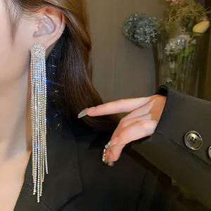 Close-up of elegant long rhinestone tassel earrings worn with a black blazer