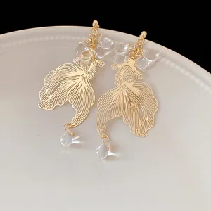 Exquisite detail of gold hollow koi fish earrings with clear crystal teardrop beads
