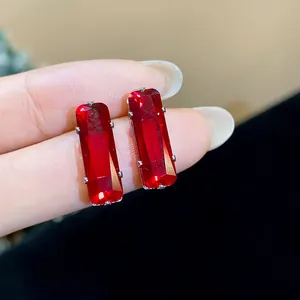 Close-up view of elegant rectangular red zircon stud earrings featuring premium silver pins