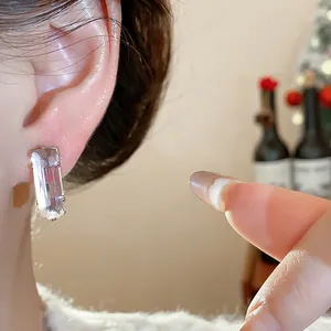 Close-up detail of elegant rectangular zircon stud earring with a silver needle post