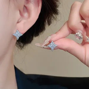 Detailed macro shot of elegant star-shaped zircon stud earrings worn by a model