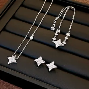 Close-up of silver four-pointed star jewelry set including necklace and earrings.