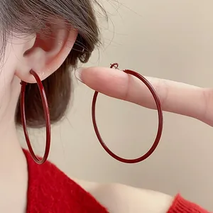 Primo piano di eleganti orecchini a cerchio rossi grandi per uno stile minimal