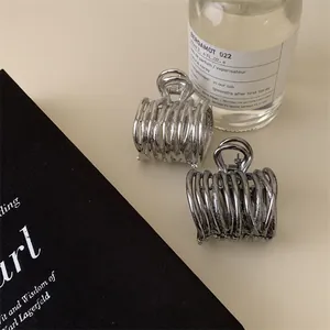 Détail de pinces à cheveux métalliques plissées irrégulières au design géométrique