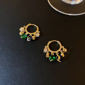 Elegante goldene Creolen im französischen Retro-Stil mit bunten Edelsteinanhängern.
