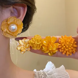 Vibrant yellow flower stud earring set featuring elegant pearl and intricate petal designs