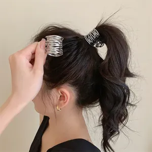Vue détaillée d'une pince à cheveux géométrique argentée sur une queue de cheval