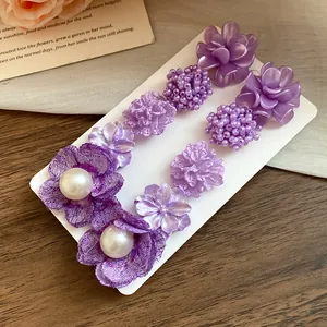 Close-up of a 10-piece purple floral earring set featuring beads and pearl details