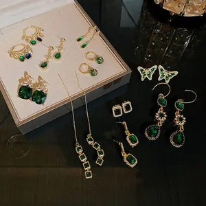 Sammlung eleganter smaragdgrüner und goldener geometrischer Ohrringe im klassischen Retro-Stil