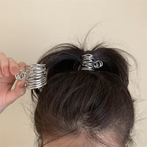 Vue détaillée d'une pince à cheveux métallique géométrique irrégulière argentée.