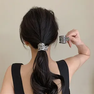 Pince à cheveux argentée au design géométrique irrégulier portée sur une queue de cheval