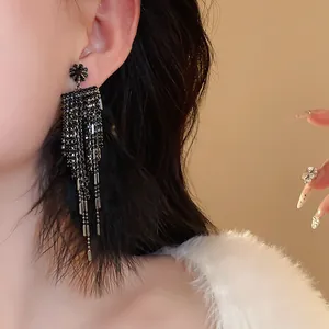 Detail of elegant vintage style black feather tassel earrings with zircon silver needles