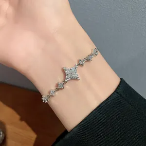 Close-up of silver-tone bracelet with sparkling star charms on female wrist