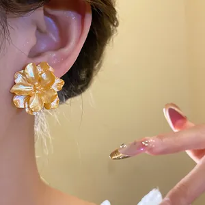 Detail view of elegant gold flower stud earrings with delicate petals for women