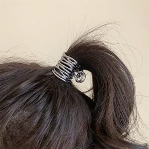 Détail macro d'une pince à cheveux géométrique irrégulière en métal argenté sur queue