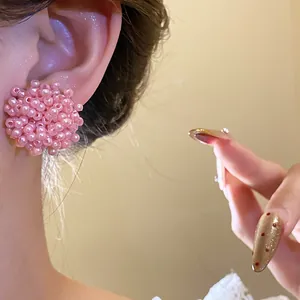 Detail view of sweet pink beaded flower stud earrings with a silver needle backing