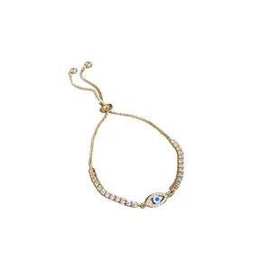Gold-tone adjustable tennis bracelet featuring sparkling zircon and blue evil eye charm