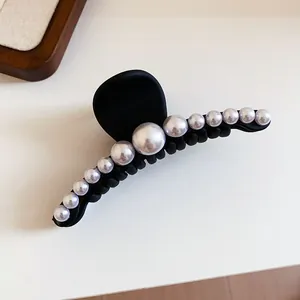 Detailed view of an elegant French style black hair claw clip with white pearls