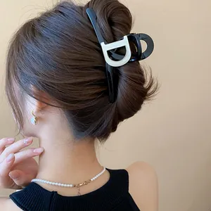 Close-up detail of an elegant black French-style hair claw clip worn on a hair bun