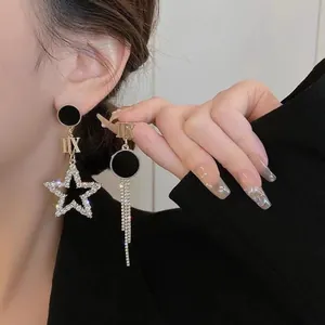 Boucles d'oreilles asymétriques élégantes avec étoile en strass, chiffres romains et pompon