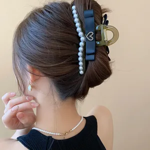Close-up of elegant French style black ribbon shark hair clip with white pearls
