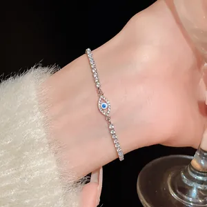 Close-up of elegant silver-tone evil eye bracelet with sparkling zircons on a model's wrist.