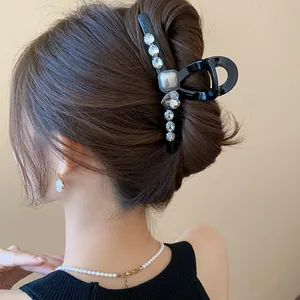 Close-up view of elegant black French-style hair claw clip with rhinestones on hair bun