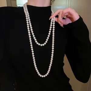 Elegante lange zweilagige Perlenkette auf einem schwarzen Rollkragenpullover präsentiert.