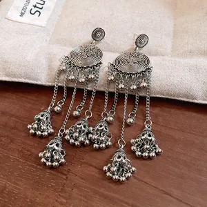Detailed macro view of vintage ethnic silver tassel earrings with delicate bell charms.