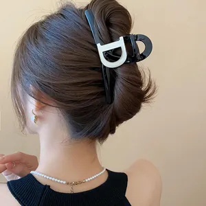 Elegant black French style hair claw clip with large letter D detail on hair
